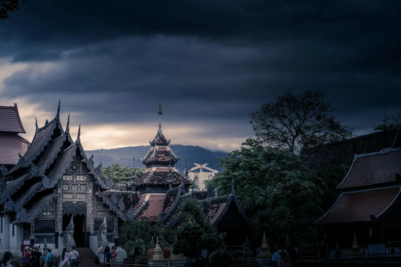 Storm clouds gather over the ornate roofs of a Buddhist temple in Chiang Mai.